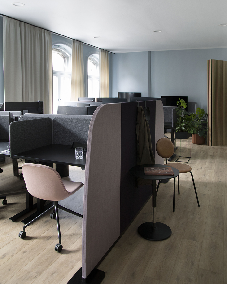 Åpent kontorlandskap med skrivebord, stoler og gardiner for et godt arbeidsmiljø. Foto.